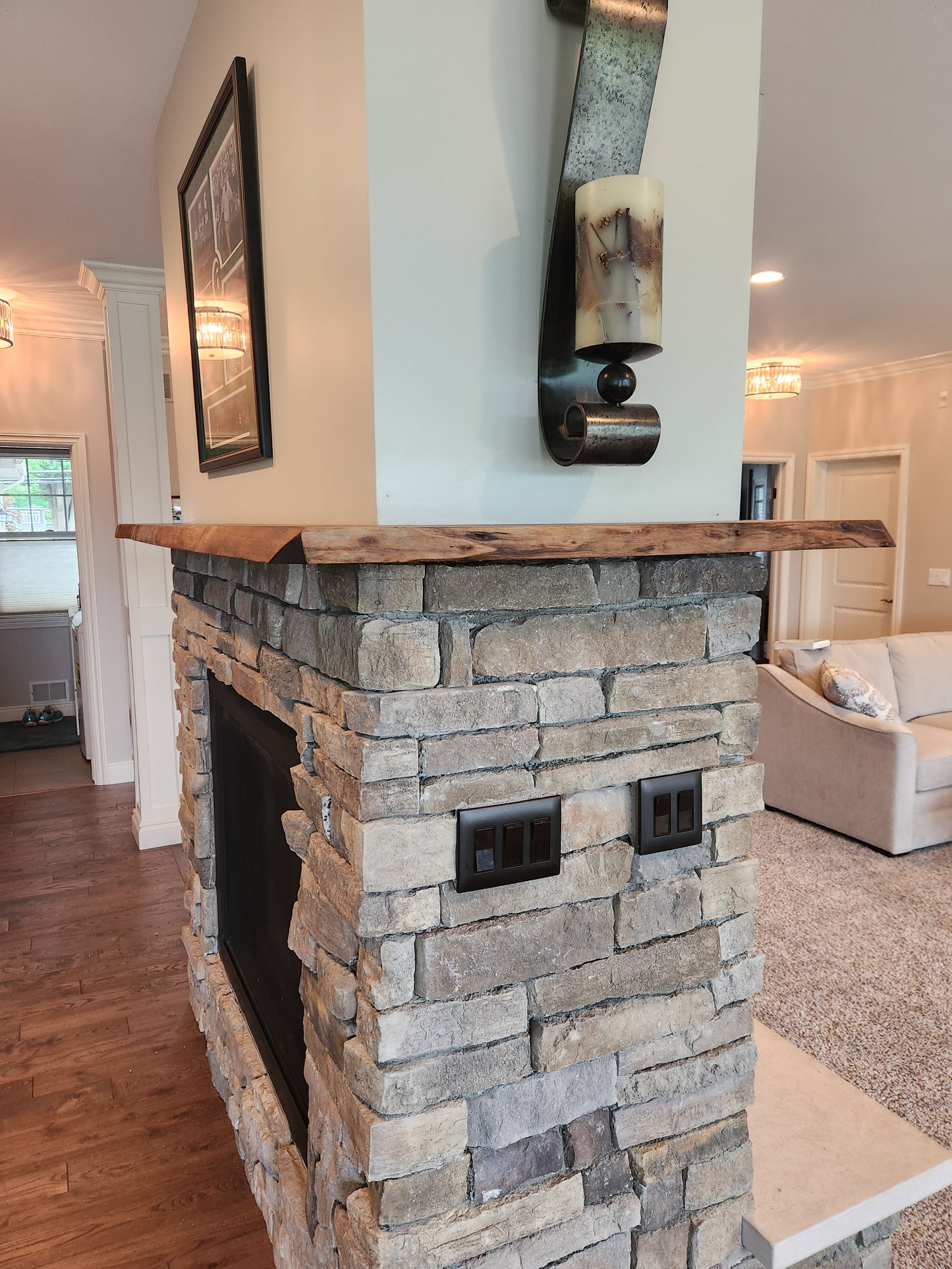 Live edge rustic walnut fireplace mantel above stone hearth