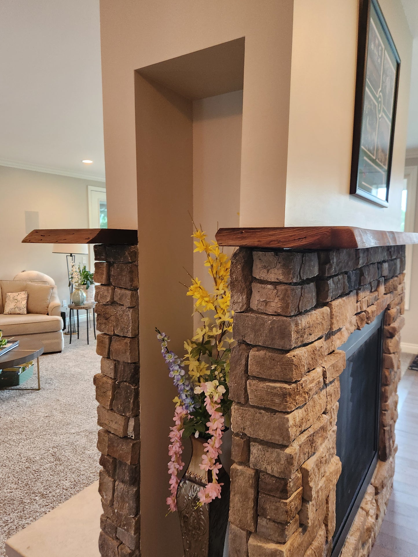 Live edge rustic walnut fireplace mantel above stone hearth