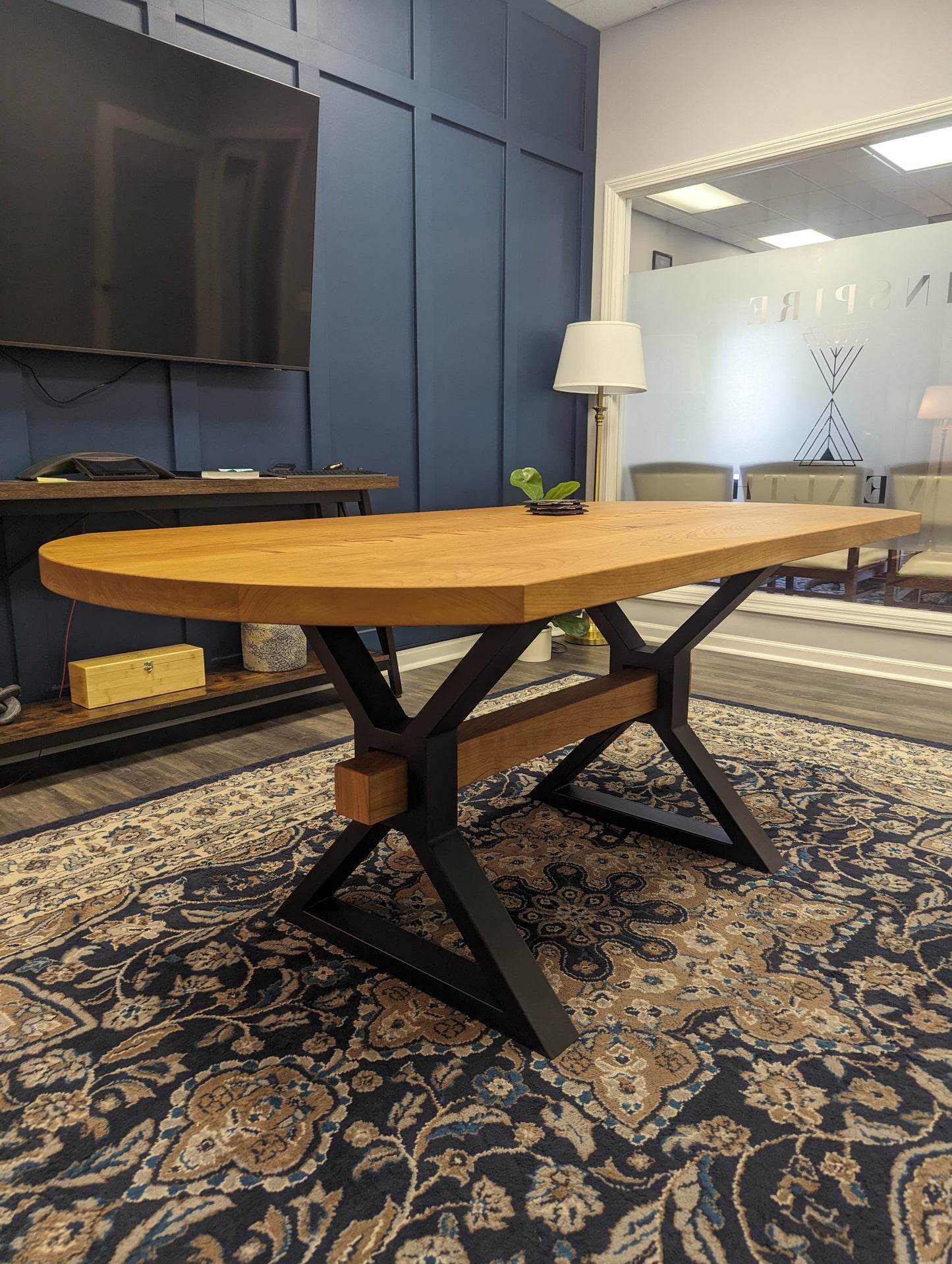 Branded cherry conference table with decorative beam in custom metal X-shaped legs