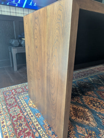 A modern stained cherry hardwood executive desk with waterfall style sides, grommets in the desk top and a hidden cord management shelf for clean storage.