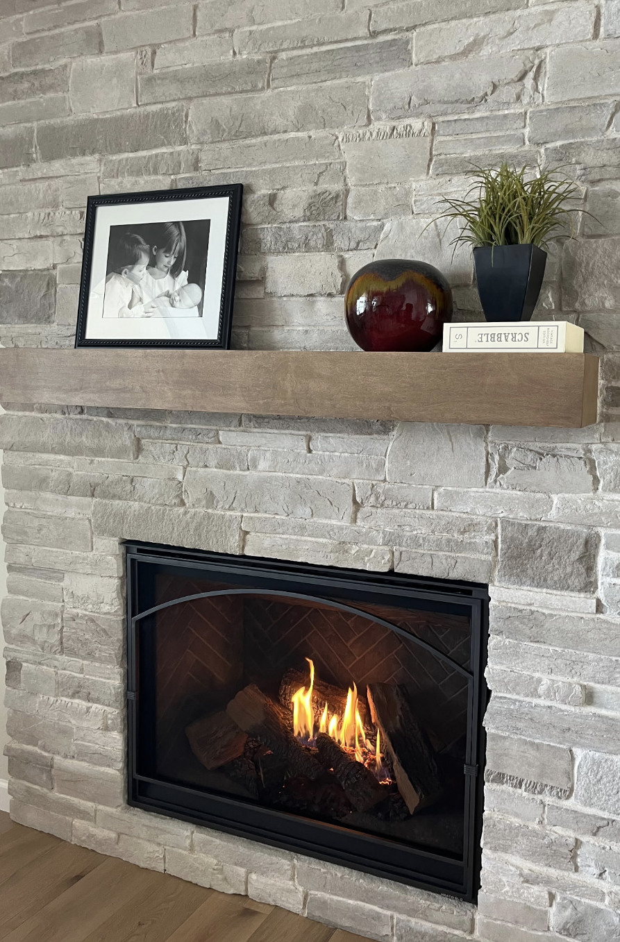 Floating maple fireplace mantel stained to complement grey stonework