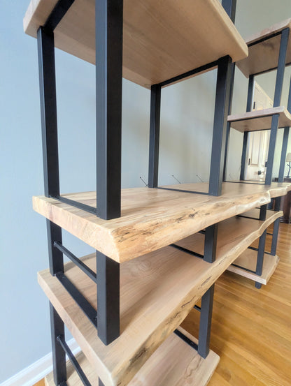 Live edge rustic ambrosia maple hardwood shelving unit with five shelves and custom fabricated black metal bars for storage of vinyl records, CDs, and corresponding players and speakers in a modern home living room.