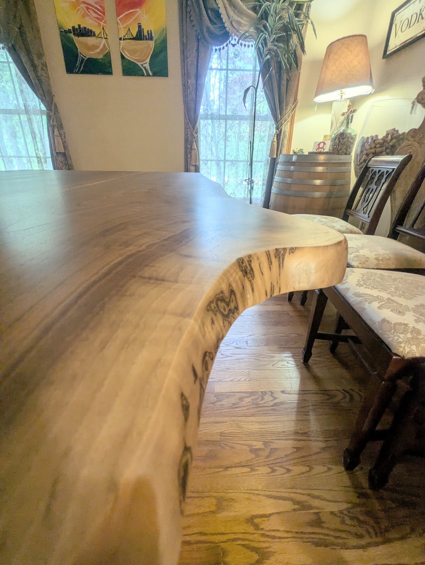 Rustic live edge walnut hardwood dining table with wood legs and a natural finish.