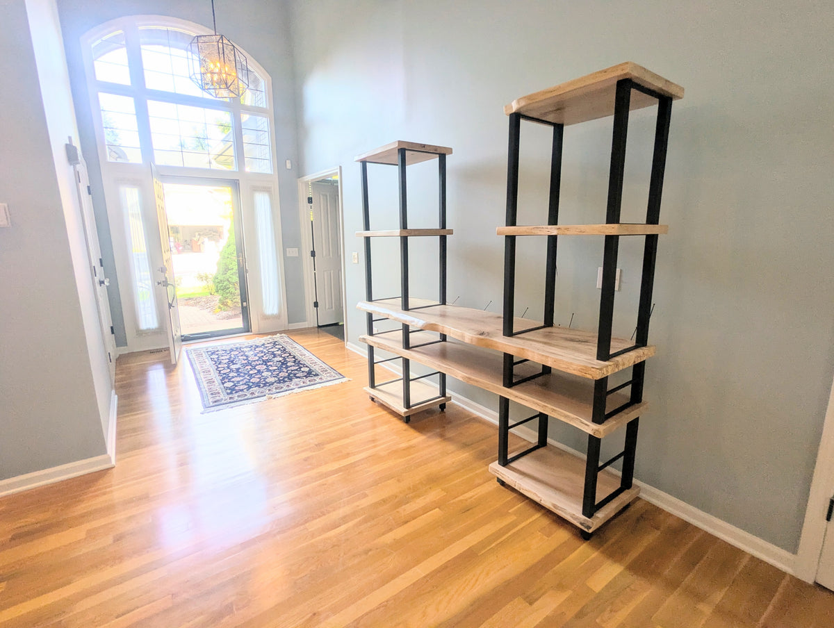 Live edge rustic ambrosia maple hardwood shelving unit with five shelves and custom fabricated black metal bars for storage of vinyl records, CDs, and corresponding players and speakers in a modern home living room.