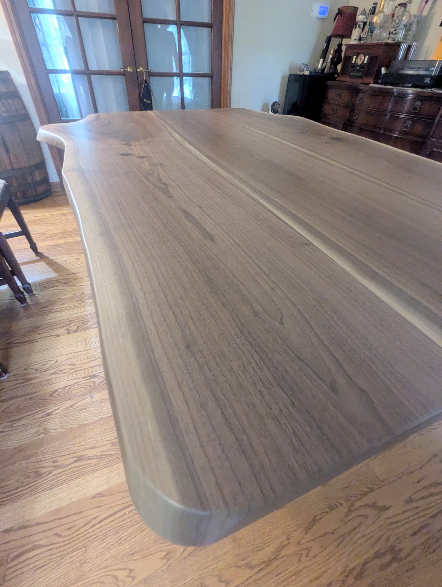 Rustic live edge walnut hardwood dining table with wood legs and a natural finish.