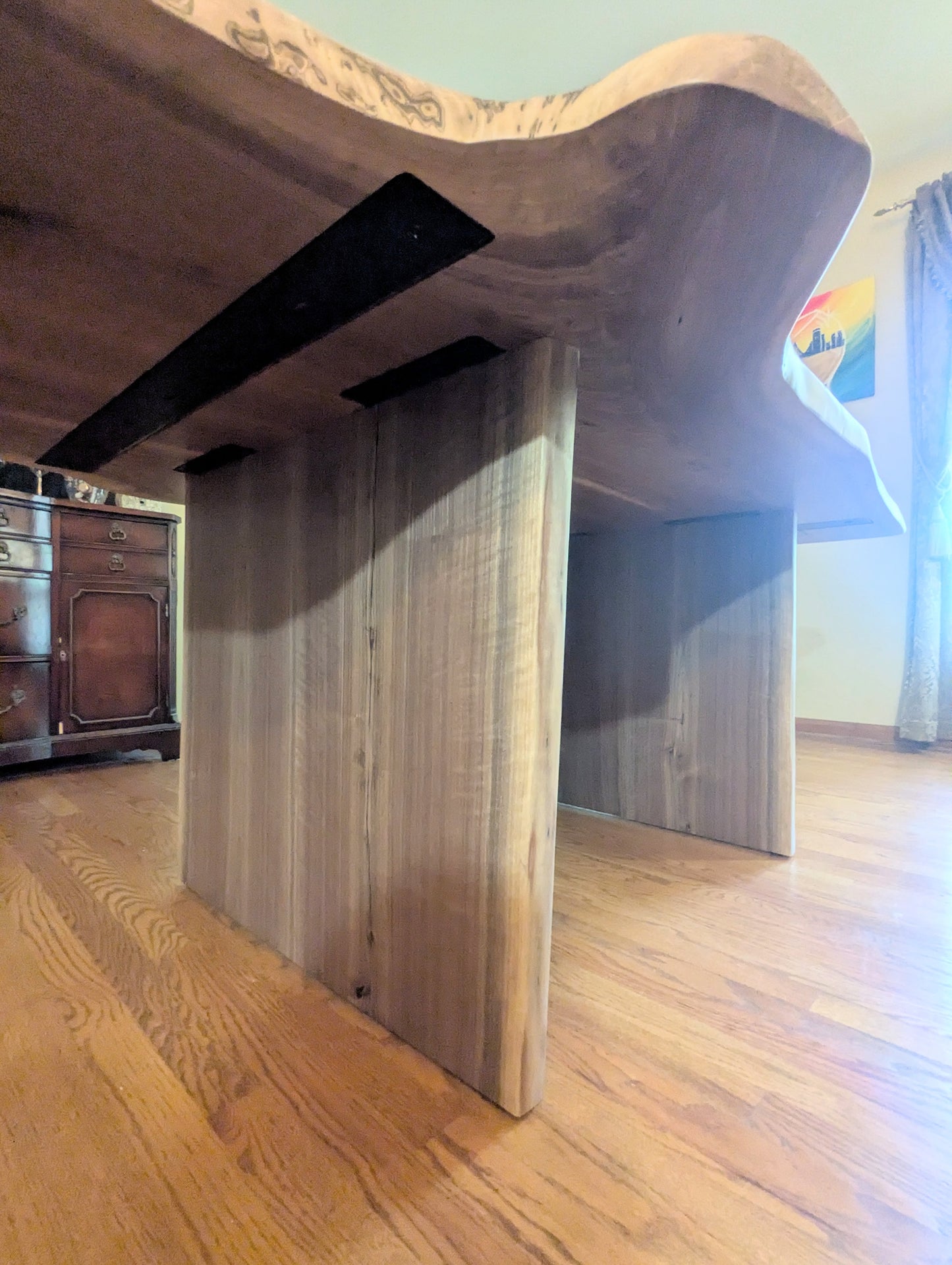 Rustic live edge walnut hardwood dining table with wood legs and a natural finish.
