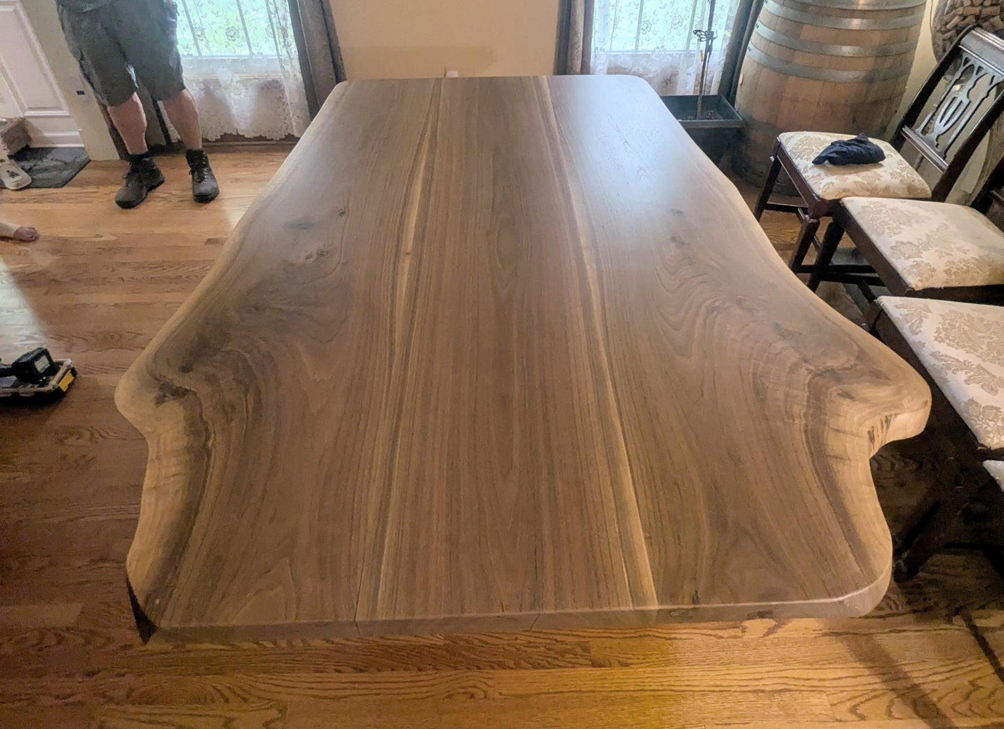 Rustic live edge walnut hardwood dining table with wood legs and a natural finish.