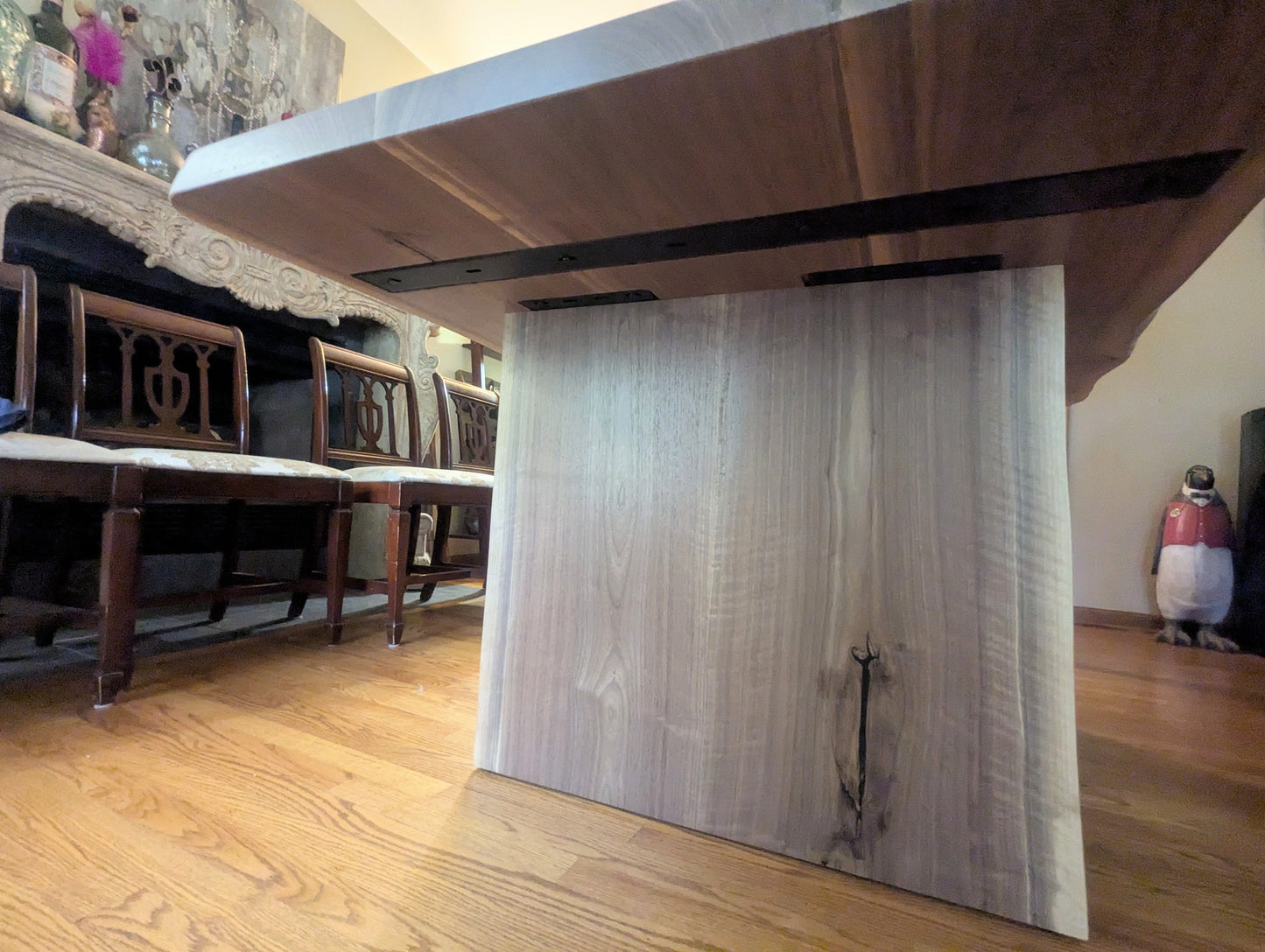 Rustic live edge walnut hardwood dining table with wood legs and a natural finish.