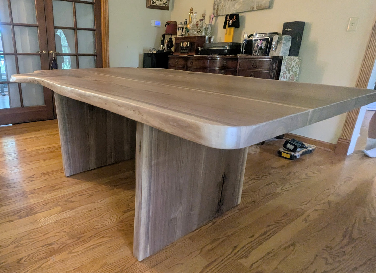 Rustic live edge walnut hardwood dining table with wood legs and a natural finish.