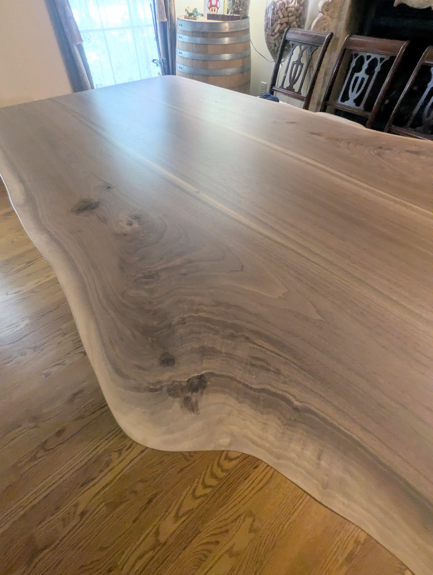 Rustic live edge walnut hardwood dining table with wood legs and a natural finish.