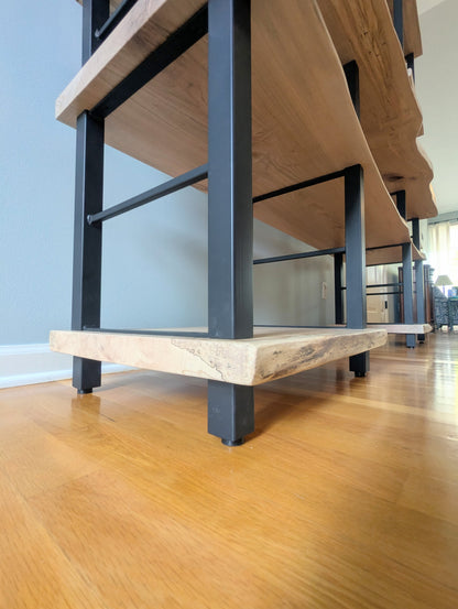Live edge rustic ambrosia maple hardwood shelving unit with five shelves and custom fabricated black metal bars for storage of vinyl records, CDs, and corresponding players and speakers in a modern home living room.