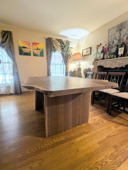 Rustic live edge walnut hardwood dining table with wood legs and a natural finish.